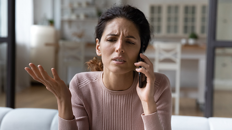 Mujer disgustada hablando por teléfono